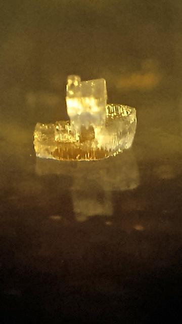 micrograph. crystal clear toy boat backlit with yellow light.